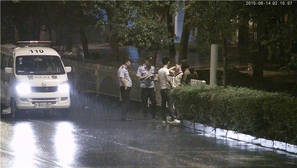 民警雨中对戴眼镜、白T恤男及女孩进行盘查.jpg